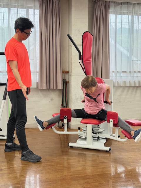 ストレッチマシンでトレーニングする女性と男性トレーナー